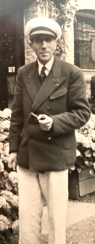 Photo de Camille Marchand debout casquette sur la tête pipe à la main